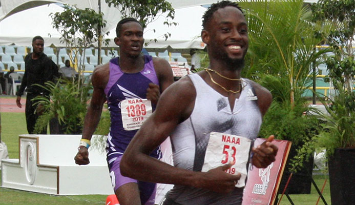 Jereem Richards eases up at the finish -line to win the men’s 200 metres title from the 2018 winner and Abilene Wildcats clubmate Kyle Greaux at the NGC/NAAATT National Open Championships at the Hasely Crawford Stadium, Mucurapo, yesterday. Richards clocked 20-14 seconds and Greaux 2018 with Akanni Hislop of Kaizen Panthers third in 20.68 seconds.