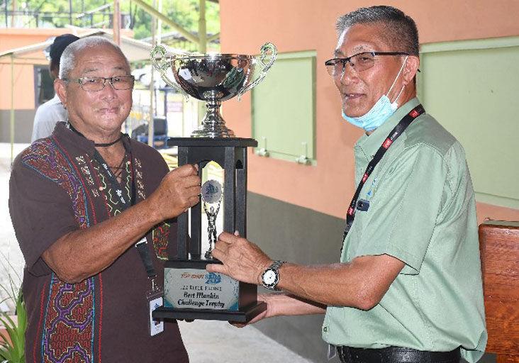 SHOOTING CHAMP: Bertram “Bert” Manhin, left, presents Victor Wingson, president of the South Trinidad Rifle Association with the Bert Manhin challenge trophy yesterday at the Association’s range, Forres Park, Claxton Bay. —Photo: TREVOR WATSON (image via: trinidadexpress.com)