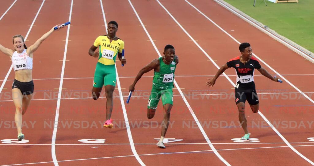 Nigeria's Isreal Sunday Okon, second from right, dips at the line to win the mixed 100m relay ahead of England's Thea Brown, left, and TT's Jamario Russell, right, at the Commonwealth Youth Games, Hasely Crawford Stadium on Thursday. Finishing fourth was Jamaica's Shaquane Gehvon Gordon. - Angelo Marcelle (Image obtained at newsday.co.tt)