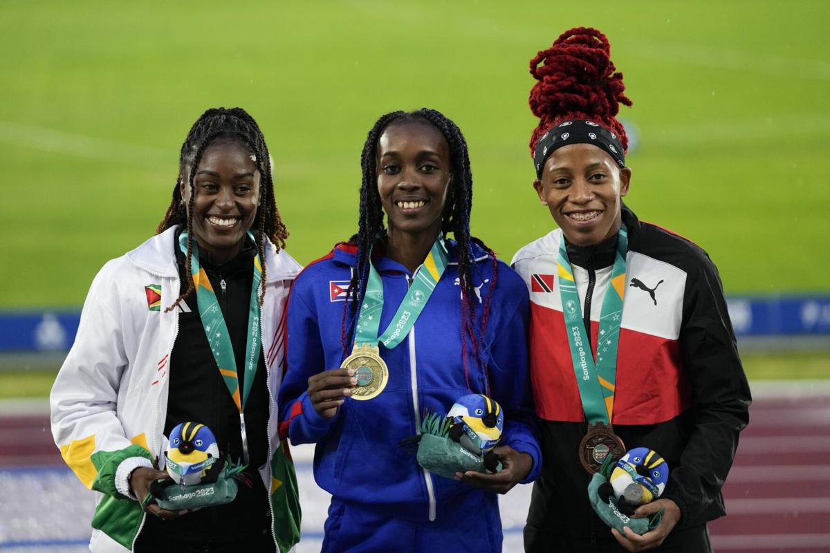 PODIUM PRIDE: Women’s 100-metre medallists, from left, Guyana’s Jasmine Abrams, silver, Cuba’s Yunisleidy Garcia, gold, and Trinidad and Tobago’s Michelle-Lee Ahye, bronze, pose on the podium at the Pan American Games in Santiago, Chile, yesterday. —Photo: AP  Silvia Izquierdo (Image obtained at trinidadexpress.com)